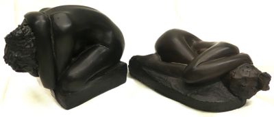 deux statues noires représentant un homme et une femme allongés sur le dos