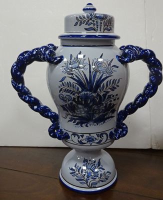 a blue and white vase sitting on a wooden table