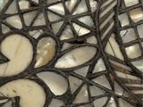 a close up of a mosaic table top with a bird on it