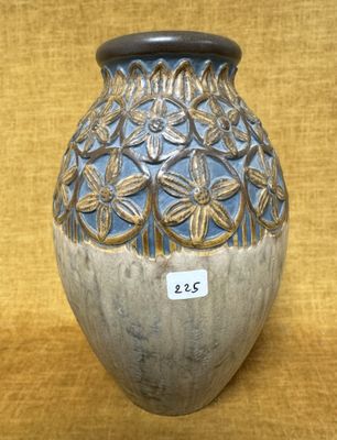 un vase bleu et blanc posé sur un tissu jaune