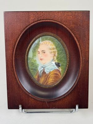 a picture of a miniature picture of a boy in a wood frame