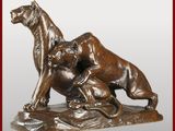 statue en bronze représentant un chien et un chat sur un rocher