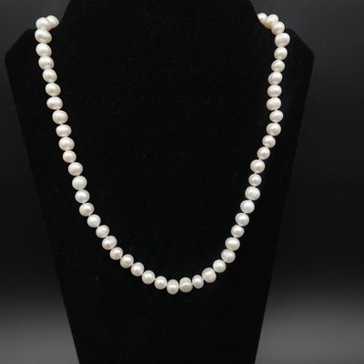 un collier de perles blanches sur un mannequin noir