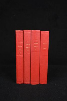 trois livres rouges empilés les uns sur les autres sur une surface noire