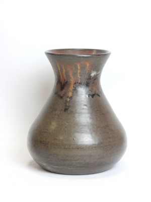 a brown vase that is sitting on a white surface