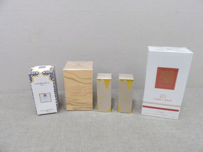 three boxes of perfume sitting next to each other on a table