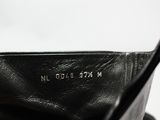 quelqu'un tient un sac à main noir sur lequel figure un nom