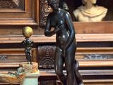 une statue représentant un homme tenant un globe terrestre, à côté d'une statue représentant un garçon