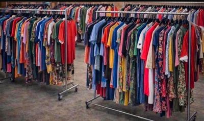 beaucoup de vêtements suspendus à une étagère dans un magasin