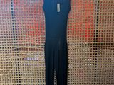 a black jumpsuit on a hanger in front of a wall