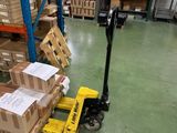 un chariot élévateur chargé de cartons dans un entrepôt