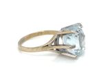 a close up of a gold ring with a blue topaz stone