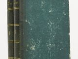 two green books sitting on top of each other on a white surface