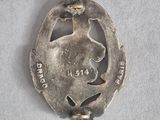 a silver brooch with a bird on top of it