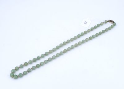 un collier de perles de jade vert muni d'un fermoir en or