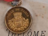 a gold medal with a red ribbon around it