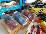 several toy cars are sitting on a table in front of a blue box