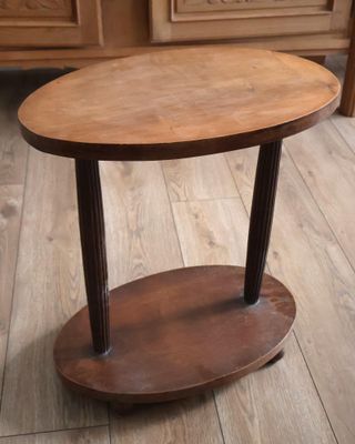 une petite table en bois avec une étagère posée à même le sol