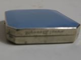 a small metal box with a blue lid on a white table