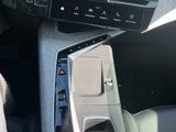 une personne est assise au volant d'une voiture, un téléphone portable à la main