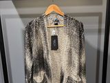 un pull noir et blanc suspendu à un cintre dans une armoire