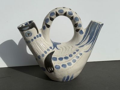 a white and blue vase with a black cat on it