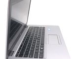 a silver laptop with a black keyboard on a white surface