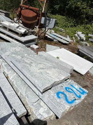 a pile of granite sitting on the ground next to a pile of concrete blocks