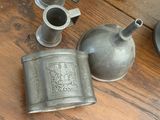 a metal flask and a cup sitting on a table