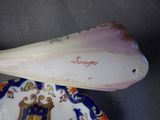 a shell shaped object on a plate with a name on it