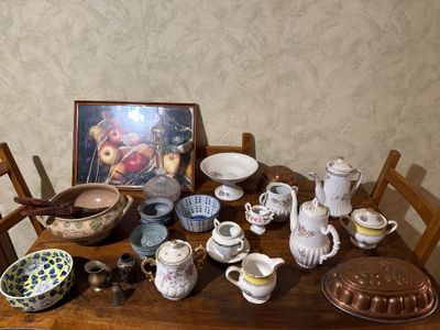 a wooden table with a bunch of dishes and bowls on it