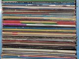 une pile de disques vinyles posée sur une table bleue