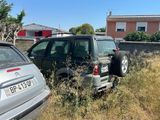 two cars parked next to each other in the grass