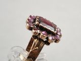 an image of a close up of a ring with a pink stone in it