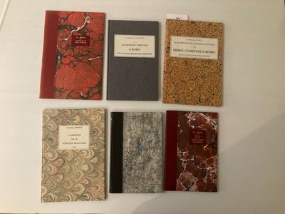 cinq livres exposés sur une table blanche
