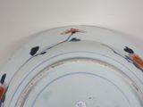 a blue and white plate with red flowers on it