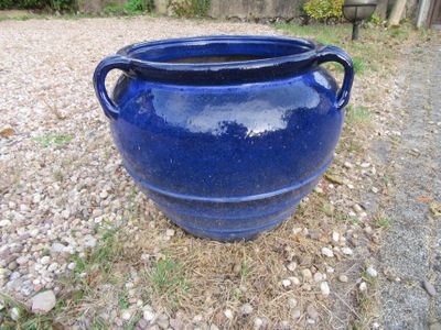 un grand pot bleu posé par terre