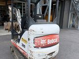 a picture of a bobcat excavator parked in front of a building