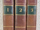 trois vieux livres posés sur une table l'un à côté de l'autre