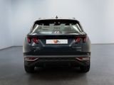 the rear end of a grey car in a white room