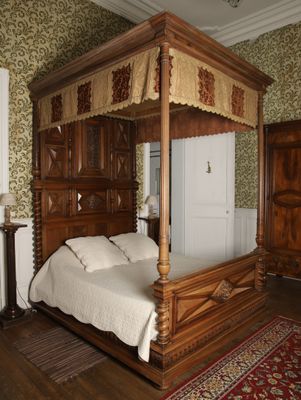 a bed with a canopy in the middle of a room