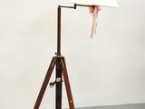 une lampe sur trépied en bois, surmontée d'un abat-jour blanc