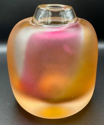 un vase en verre contenant un liquide rose et jaune