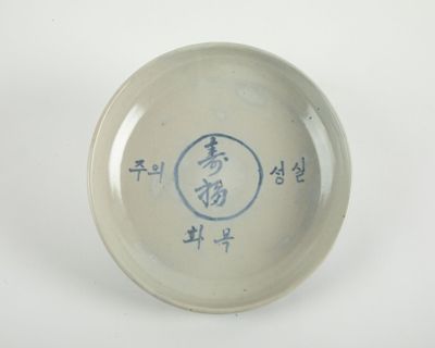un petit bol sur lequel figure une inscription, posé sur une table