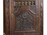 une vieille armoire en bois dont la façade est ornée de sculptures élaborées
