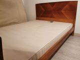 a bed with a wooden headboard and a mattress on it