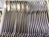 a lot of silver spoons in a white box