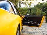 a yellow car with its door open on a cobblestone road