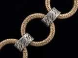 two silver and gold bracelets on a black background