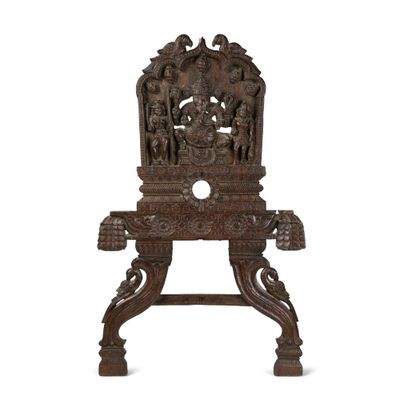 une vieille chaise en bois dont le dossier est sculpté